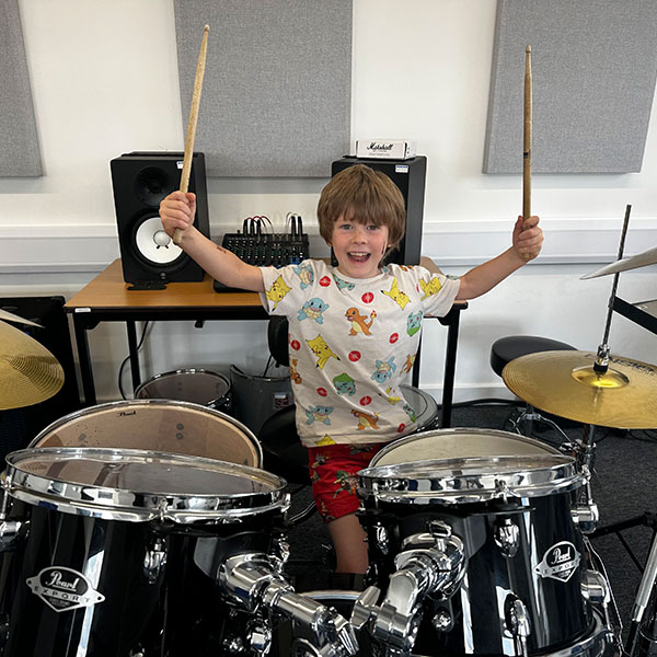 Young boy learning to play drums at Wrexham Sounds